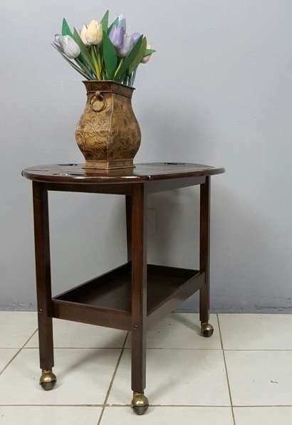 An exquisite Teak "Butlers" trolley on castors with brass hinges; Opens into a removable oval table