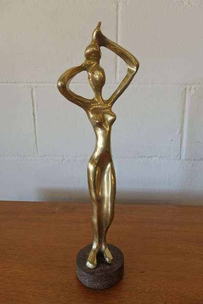 An incredible (tall) solid brass abstract figurine on a wooden stand in stunning condition