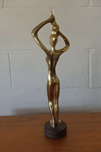 An incredible (tall) solid brass abstract figurine on a wooden stand in stunning condition