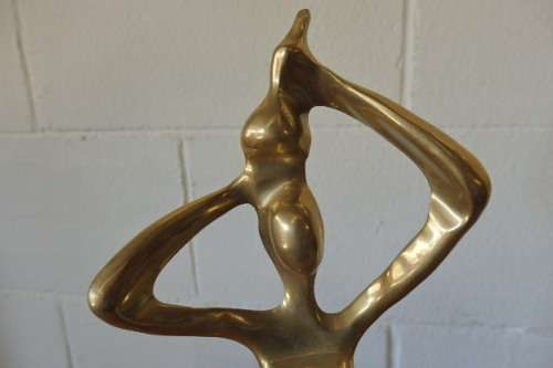 An incredible (tall) solid brass abstract figurine on a wooden stand in stunning condition