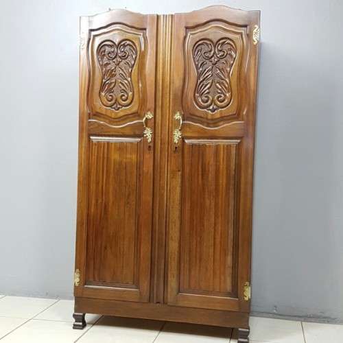 A stunning carved double-door solid Imbuia wardrobe with solid brass embellishments & ample space