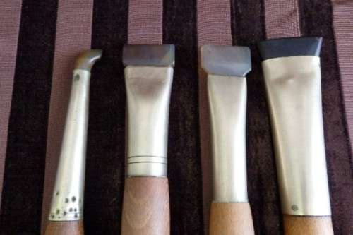 An incredible set of four vintage sculpting tools with wooden handles, brass cuffs & celluloid tips