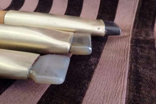 An incredible set of four vintage sculpting tools with wooden handles, brass cuffs & celluloid tips