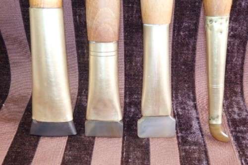 An incredible set of four vintage sculpting tools with wooden handles, brass cuffs & celluloid tips