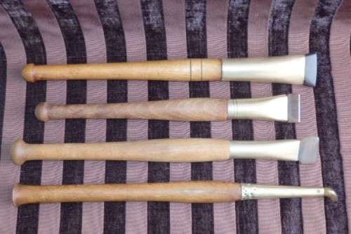 An incredible set of four vintage sculpting tools with wooden handles, brass cuffs & celluloid tips