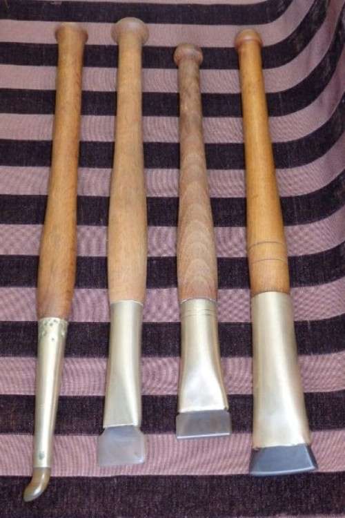 An incredible set of four vintage sculpting tools with wooden handles, brass cuffs & celluloid tips