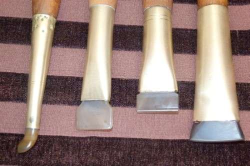 An incredible set of four vintage sculpting tools with wooden handles, brass cuffs & celluloid tips
