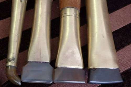 An incredible set of four vintage sculpting tools with wooden handles, brass cuffs & celluloid tips