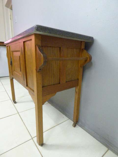 A spectacular vintage Oak wash stand with a solid black marble top & spacious cupboard on castors