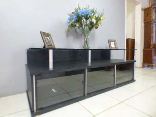 A stunning stylish TV stand with place for your entertainment centre and a thick glass top RS17