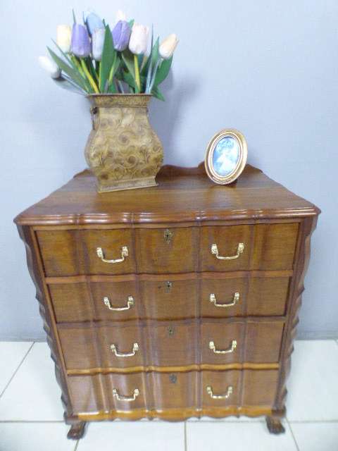 An exquisite vintage Imbuia 4-drawer chest of drawers with ornate handles and ample storage space