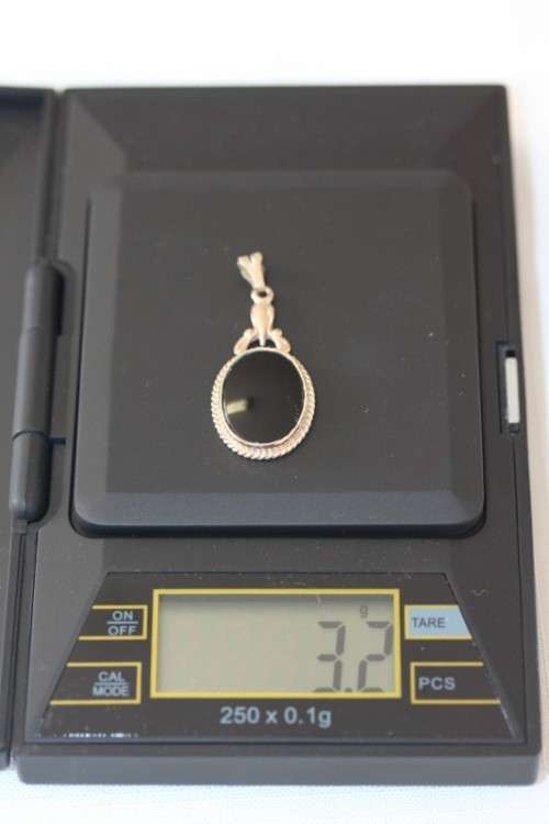 A magnificent 9ct gold pendant with large Onyx stone and amazing braiding around the edges