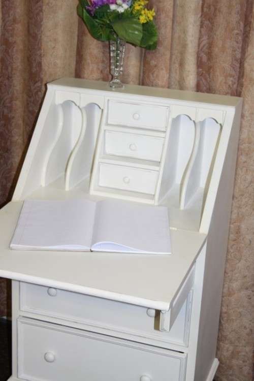 A stunning "eggshell" white flip-top writing desk with three large drawers and three smalls drawers