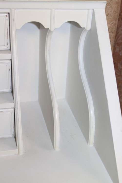 A stunning "eggshell" white flip-top writing desk with three large drawers and three smalls drawers