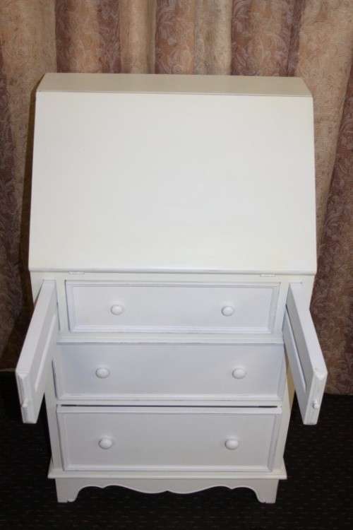 A stunning "eggshell" white flip-top writing desk with three large drawers and three smalls drawers