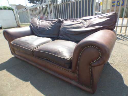 A stunning x-large modern styled brown genuine leather couch in great condition. RS17