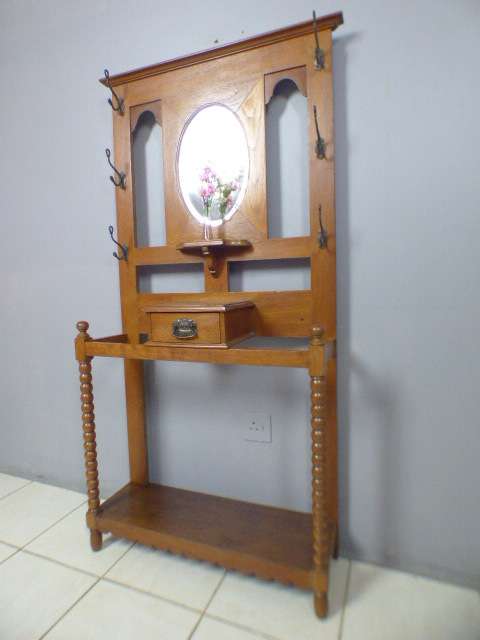 A stunning tall Teak hall stand with a beveled mirror, drawer and 6 hooks in great condition.