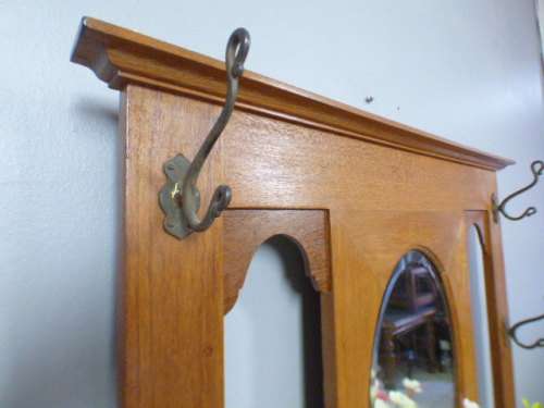 A stunning tall Teak hall stand with a beveled mirror, drawer and 6 hooks in great condition.