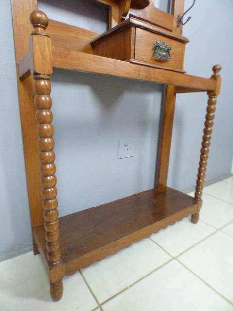 A stunning tall Teak hall stand with a beveled mirror, drawer and 6 hooks in great condition.