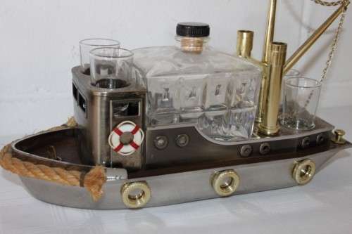 An amazing vintage tugboat decanter with a wind-up music box and four shot glasses