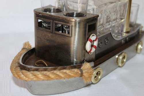 An amazing vintage tugboat decanter with a wind-up music box and four shot glasses