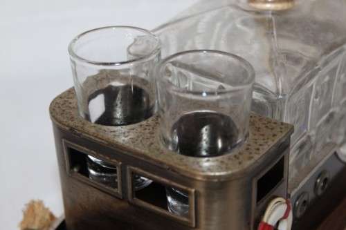 An amazing vintage tugboat decanter with a wind-up music box and four shot glasses