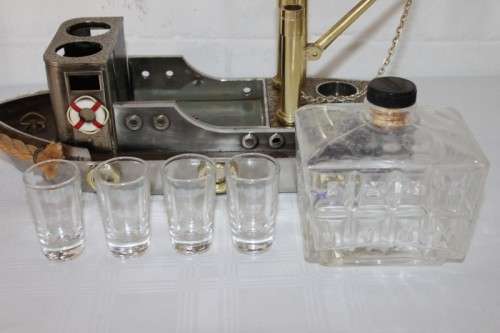An amazing vintage tugboat decanter with a wind-up music box and four shot glasses