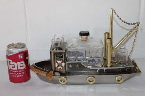 An amazing vintage tugboat decanter with a wind-up music box and four shot glasses