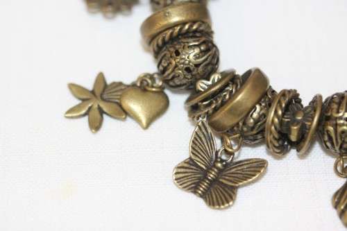 **RS17** A "chunky" ladies elasticised metal-beaded charm bracelet with an array of charms