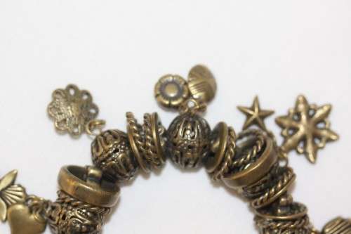 **RS17** A "chunky" ladies elasticised metal-beaded charm bracelet with an array of charms