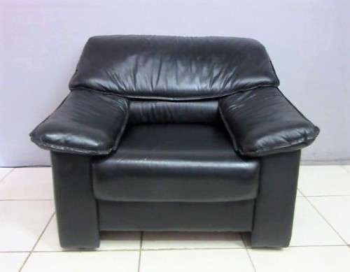 A beautiful well made black genuine leather single sofa with padded armrests & comfortable seating!!