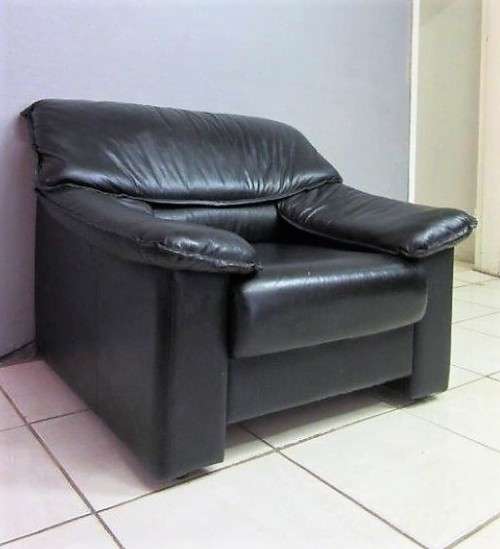 A beautiful well made black genuine leather single sofa with padded armrests & comfortable seating!!