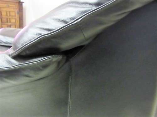 A beautiful well made black genuine leather single sofa with padded armrests & comfortable seating!!