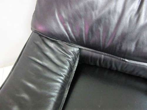 A beautiful well made black genuine leather single sofa with padded armrests & comfortable seating!!