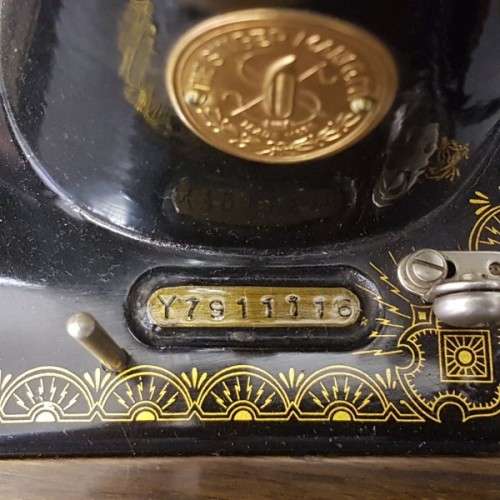 An incredible vintage (1930) singer "treadle" sewing machine in its cabinet in wonderful condition