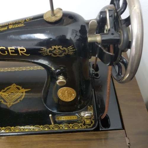 An incredible vintage (1930) singer "treadle" sewing machine in its cabinet in wonderful condition