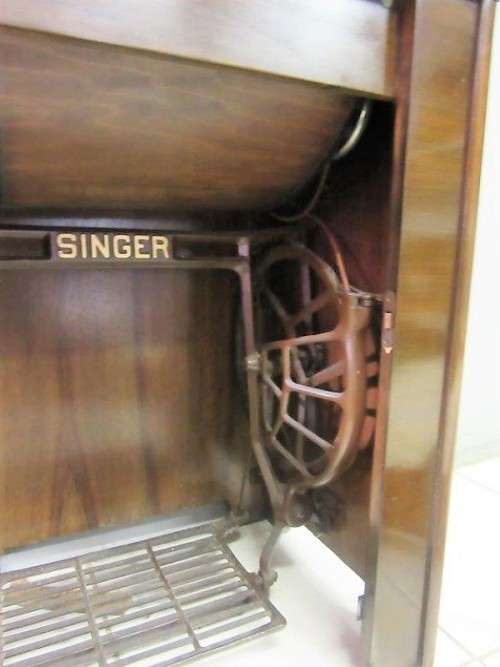 An incredible vintage (1930) singer "treadle" sewing machine in its cabinet in wonderful condition