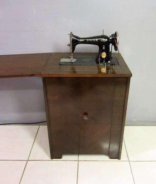 An incredible vintage (1930) singer "treadle" sewing machine in its cabinet in wonderful condition