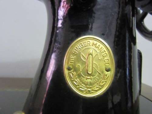 An incredible vintage (1930) singer "treadle" sewing machine in its cabinet in wonderful condition