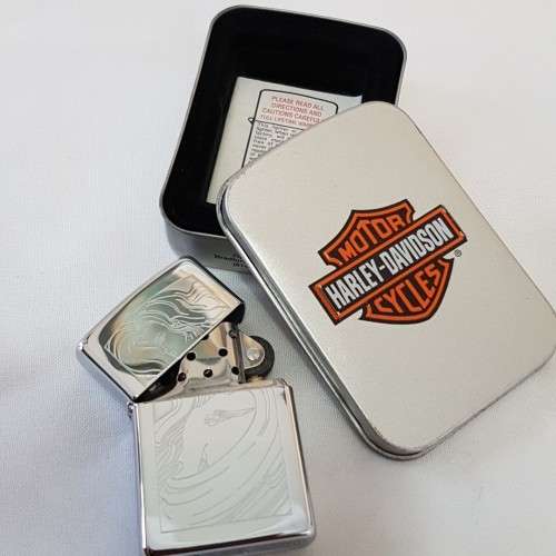 A fantastic polished chrome engraved "Girl with Harley Tattoo" Zippo lighter in box
