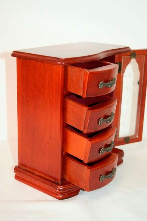 A wonderful wooden upright jewellery box with four drawers, ring slots & a rotating necklace holder