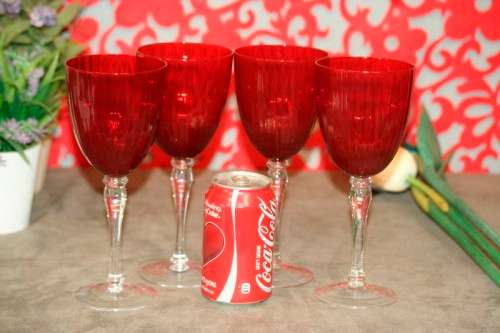 A stylish and modern boxed set of 4x tall wine glasses in a deep red colour with clear glass stems