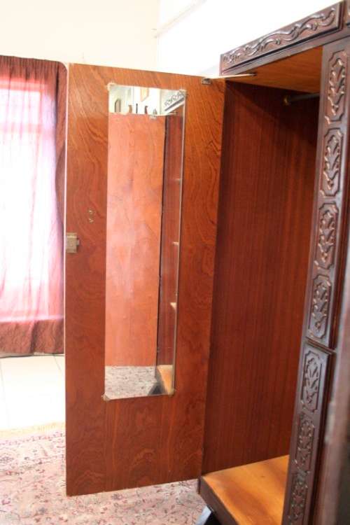 A stunning Imbuia-finished double door wardrobe with hand carved rosettes and facade detailing