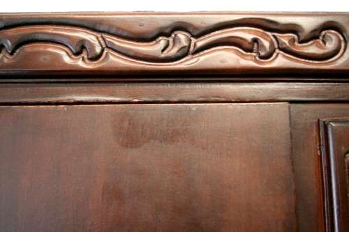 A stunning Imbuia-finished double door wardrobe with hand carved rosettes and facade detailing