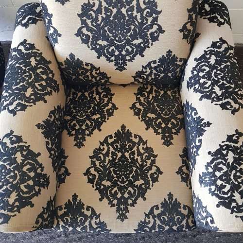 A one seater sofa chair upholstered in a stunning brocade fabric with wooden legs