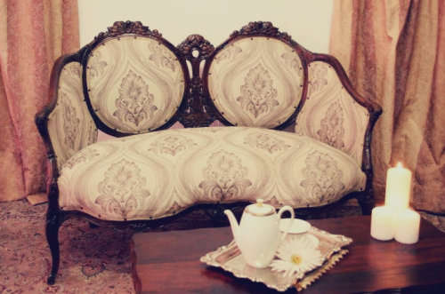 An exquisite antique Victorian carved settee with stylish new upholstery.