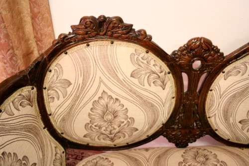 An exquisite antique Victorian carved settee with stylish new upholstery.