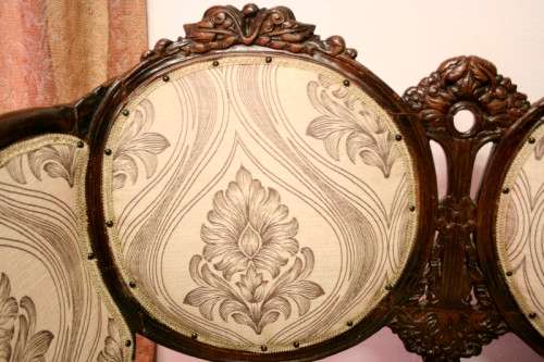 An exquisite antique Victorian carved settee with stylish new upholstery.