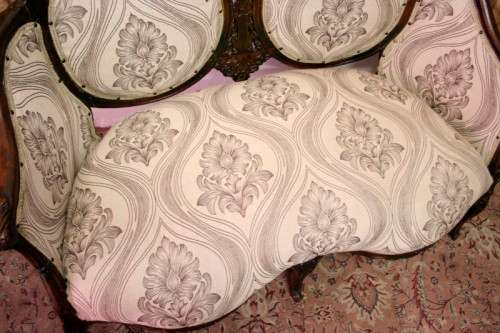 An exquisite antique Victorian carved settee with stylish new upholstery.