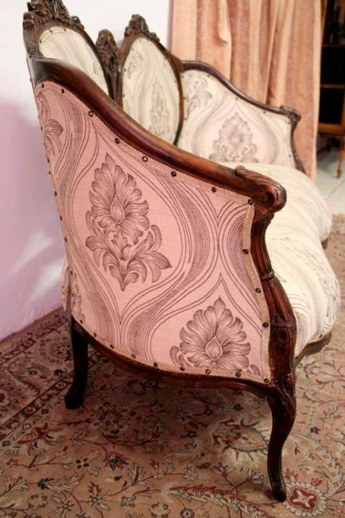 An exquisite antique Victorian carved settee with stylish new upholstery.